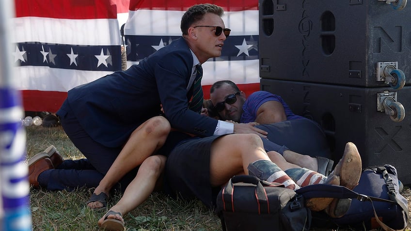 A Secret Service member and members of the crowd are seen at republican presidential candidate former President Donald Trump's rally