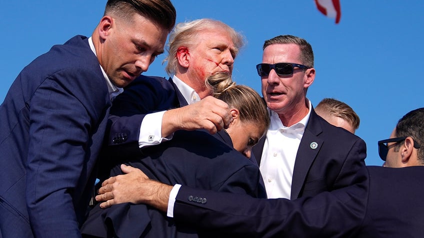 Donald Trump is surrounded by U.S. Secret Service agents at a campaign rally