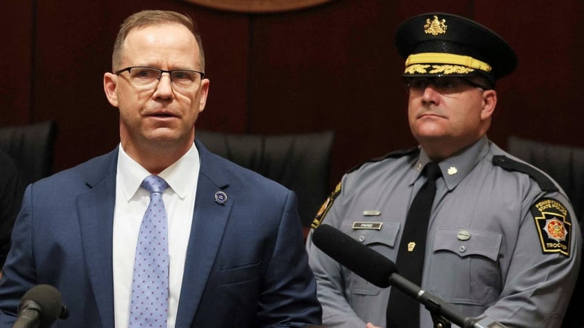 Pennsylvania State Police Colonel Christopher Paris in full uniform standing on the right during a news briefing