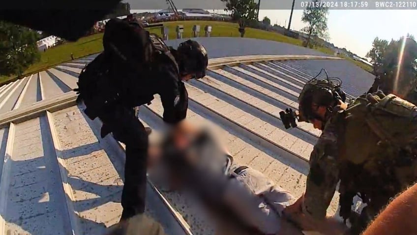 Officers stand over Thomas Crooks on the AGR building roof