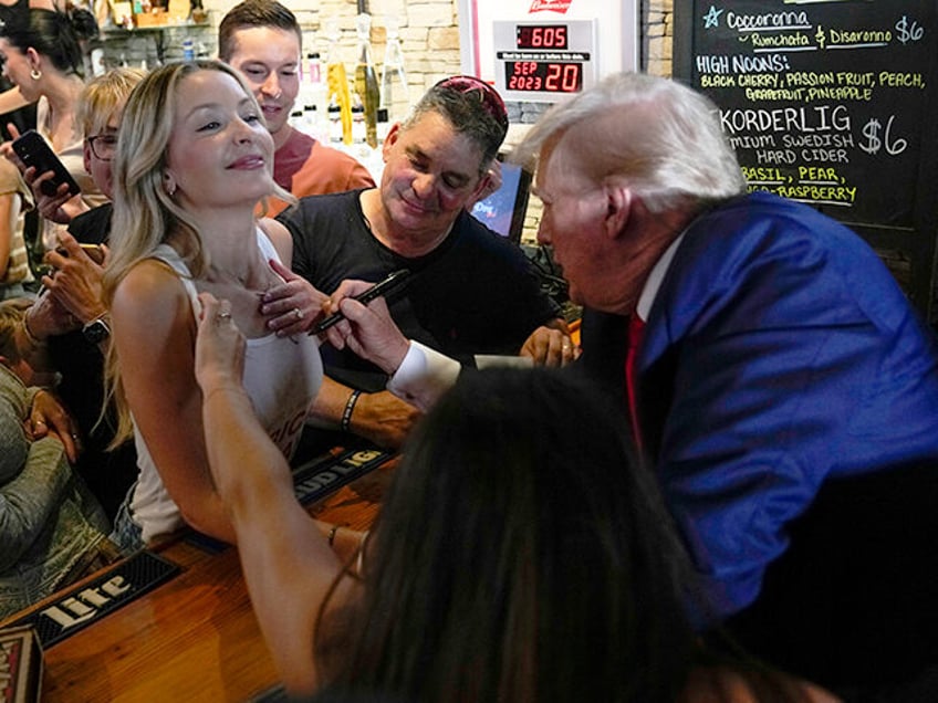 trump autographs womans shirt in iowa bar