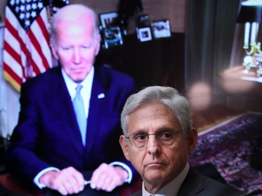 As U.S. President Joe Biden, appearing via teleconference, looks on Attorney General Merri