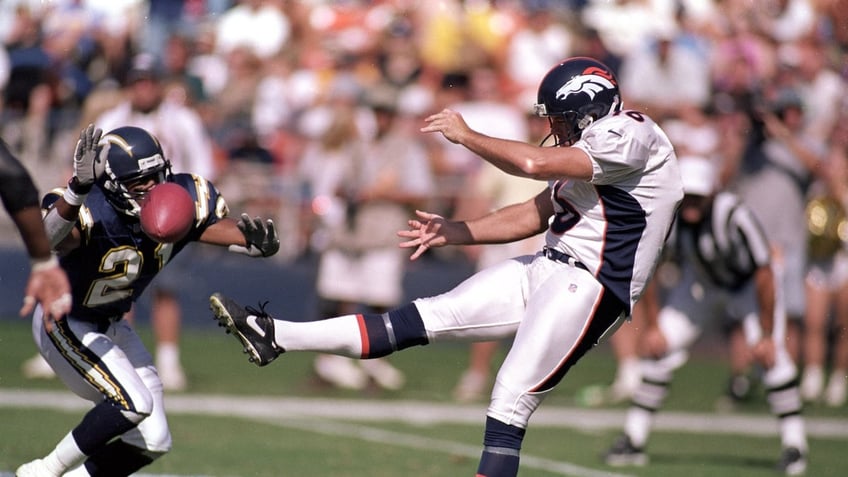 Kicker Tom Rouen of the Denver Broncos punts the ball, and it is blocked by Scott Turner (21) of the San Diego Chargers at Qualcomm Stadium in San Diego.