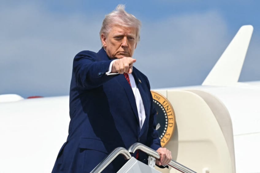 US President Donald Trump points as he boards Air Force One prior to departure from Joint