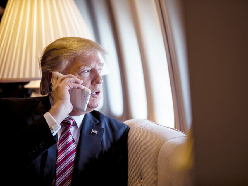 President Donald Trump talks on the phone aboard Air Force One during a flight to Philadel