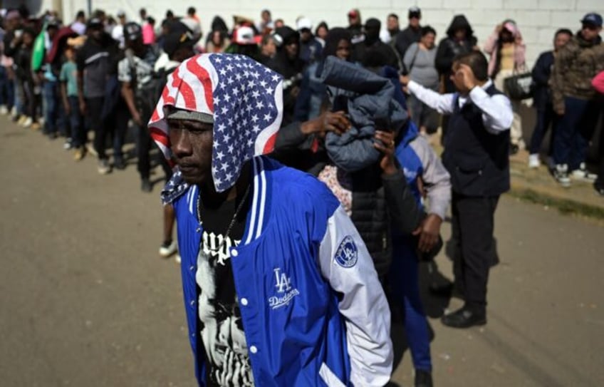 Migrants wait outside an office of the Mexican Commission for Refugee Assistance near Mexi