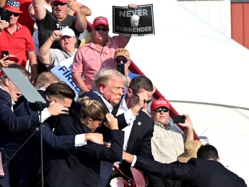 Former US President Donald Trump is surrounded by Secret Service agents during a campaign