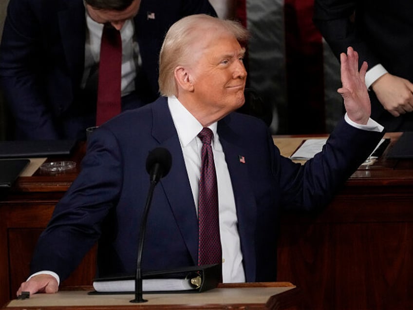 President Donald Trump waves to first lady Melania Trump as he addresses a joint session o