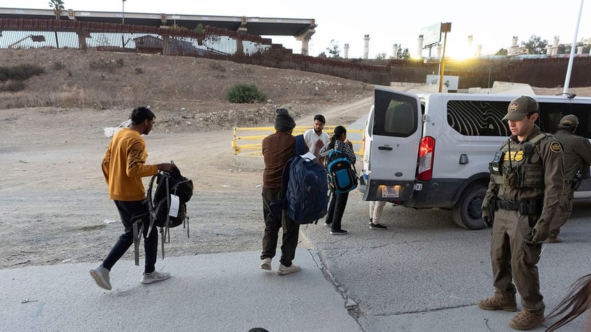 Migrants with Border Patrol agents