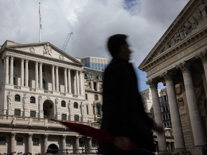 LONDON, ENGLAND - MAY 11: A man holding an umbrella walks past the Bank of England ahead o