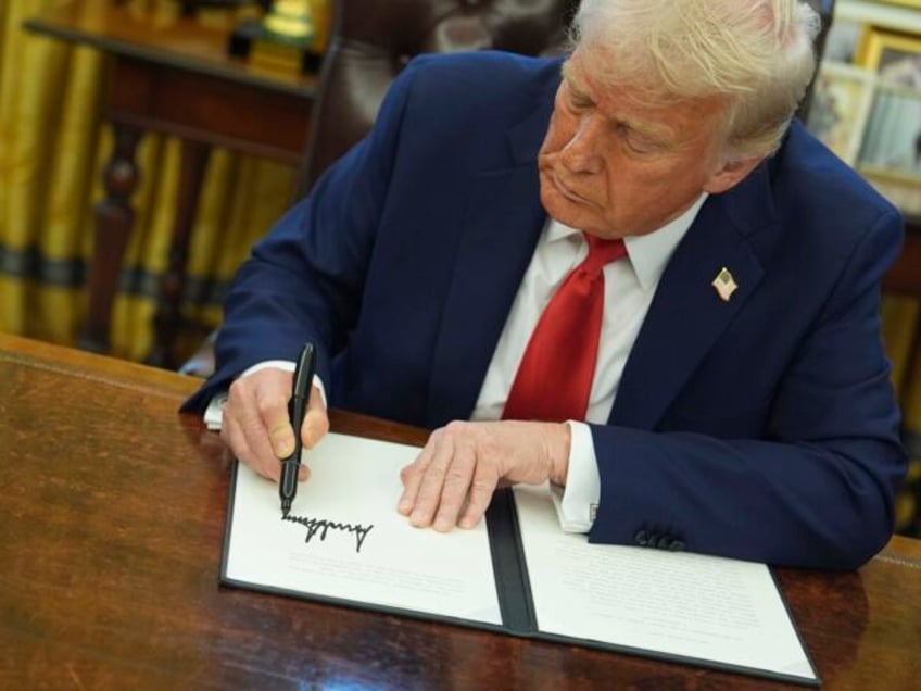 President Donald Trump signs an executive order in the Oval Office of the White House, Mon