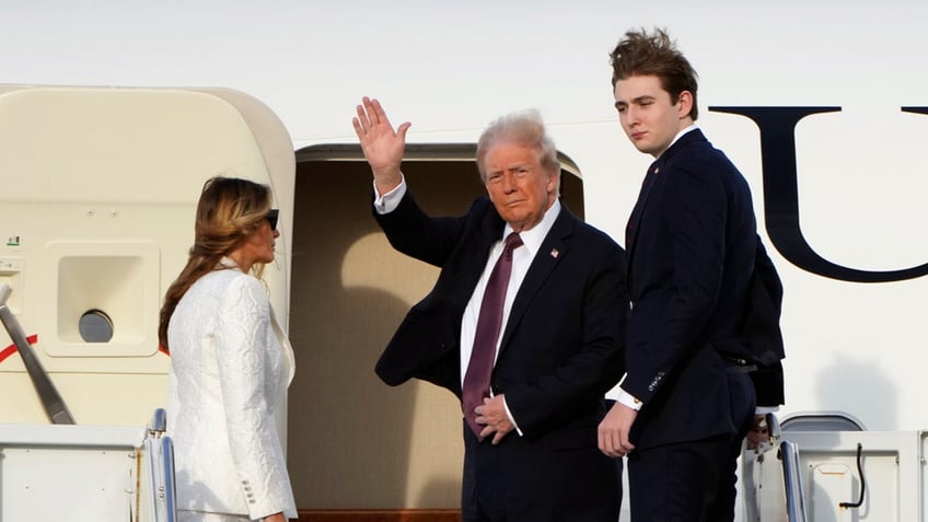 President-elect Donald Trump, standing with Melania and Barron Trump, waves as they board an Air Force Special Mission airplane at Palm Beach International Airport on Saturday, in West Palm Beach, Fla., en route to Washington. 