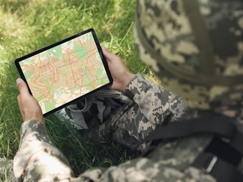 Soldier using GPS locator on tablet