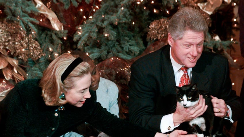 FILE - In this Dec. 20, 1996, file photo President Clinton holds Socks the cat as he and first lady Hillary Clinton host Washington area elementary school children at the White House where the president read "Twas the Night Before Christmas." (AP Photo/Ruth Fremson, File)