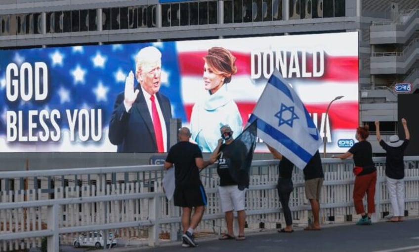 Then-US president Donald Trump and his wife Melania Trump are seen on a jumbo screen in Te