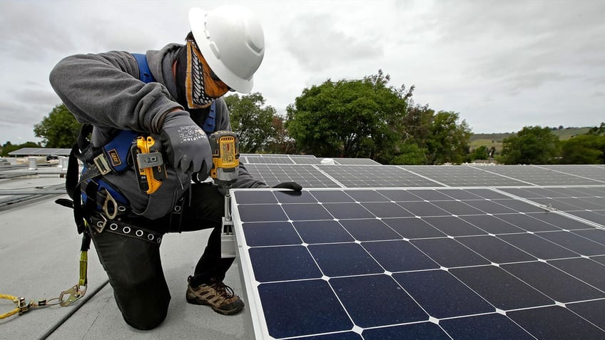 man installing solar panels