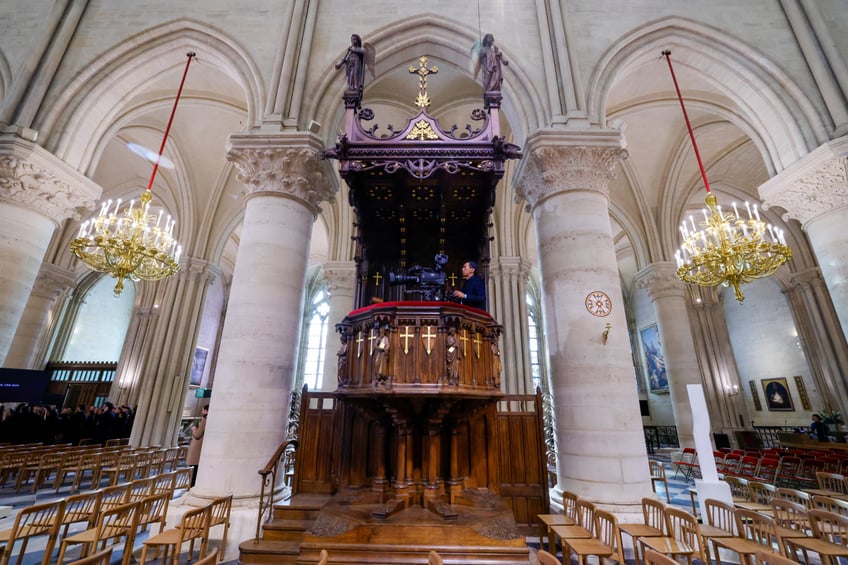 A photo shows a television cameraman inside the Notre-Dame de Paris cathedral, ahead of its official reopening ceremony after more than five years of reconstruction work following the April 2019 fire, in Paris on December 7, 2024. Notre-Dame Cathedral is set to re-open early December 2024, with a weekend of ceremonies on December 7 and 8, 2024, five years after the 2019 fire which ravaged the world heritage landmark and toppled its spire. Some 250 companies and hundreds of experts were mobilised for the five-year restoration costing hundreds of millions of euros. (Photo by Ludovic MARIN / POOL / AFP) (Photo by LUDOVIC MARIN/POOL/AFP via Getty Images)