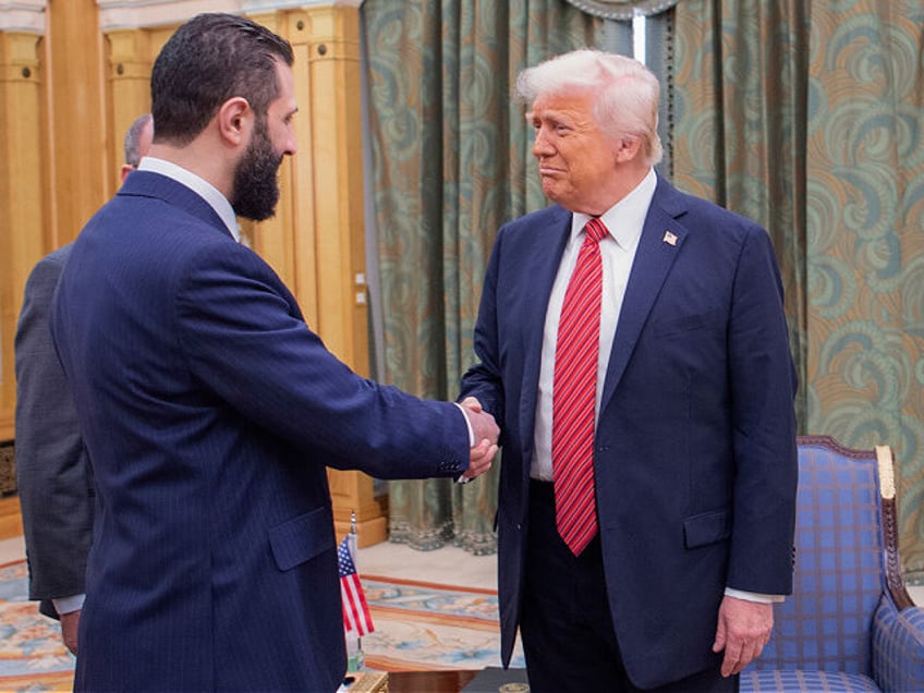 In this photo released by the Saudi Royal Palace, President Donald Trump, right, shakes ha