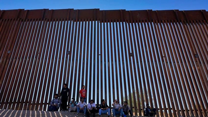 migrants at border wall