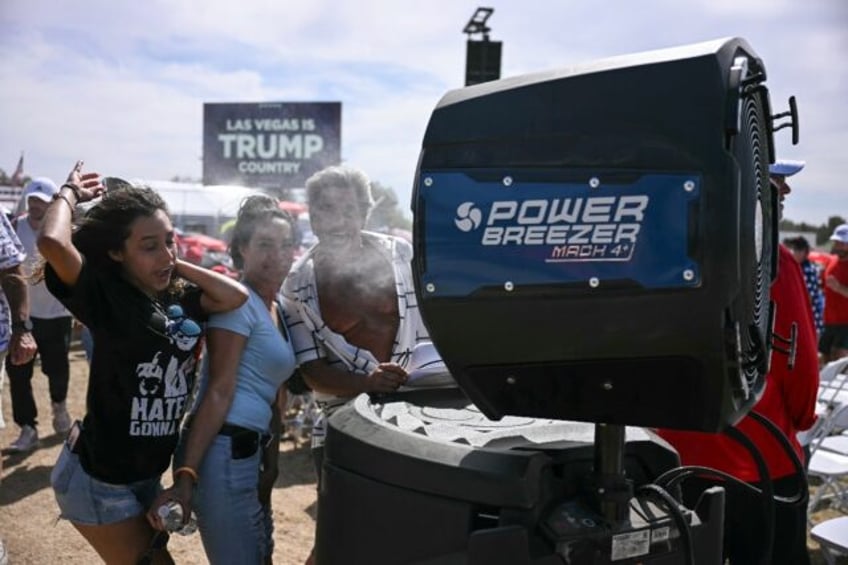 Donald Trump supporters cool off as they attend the Republican candidate's rally in Las Ve