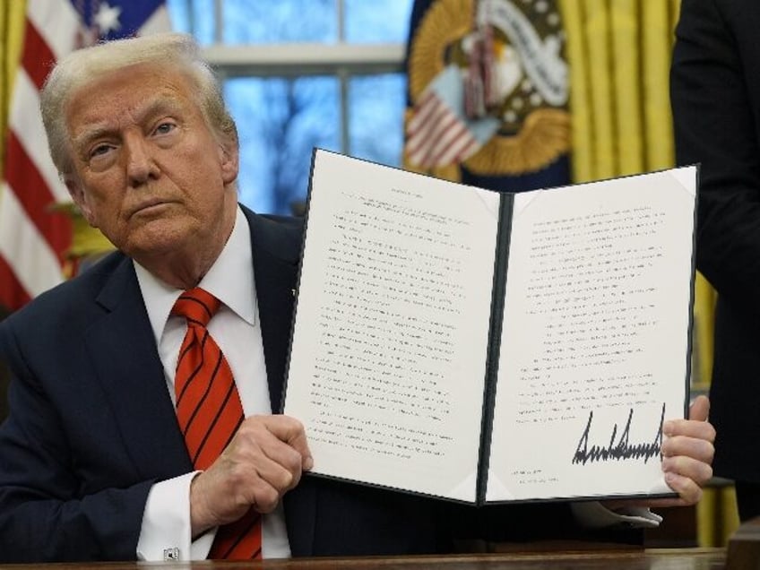 President Donald Trump holds up an executive order relating to the Foreign Corrupt Practic