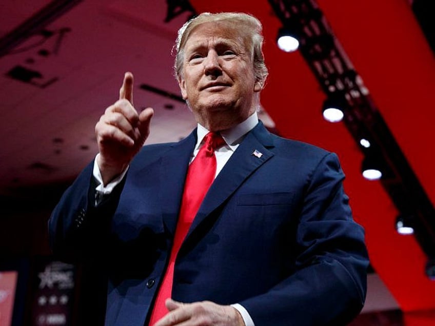 President Donald Trump looks to the cheering audience as he arrives to speak at Conservati