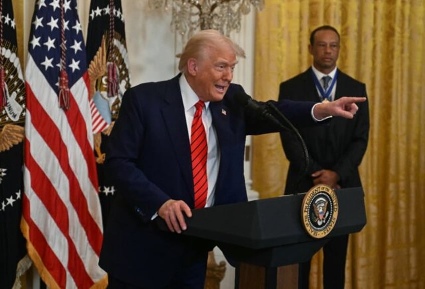 US golf legend Tiger Woods, right watches as President Donald Trump speaks during a Black