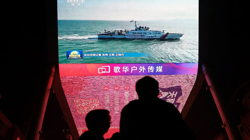 A giant screen in Beijing shows news footage of military drills conducted in the Taiwan Strait and near Taiwan by the Chinese People's Liberation Army on Oct. 14.