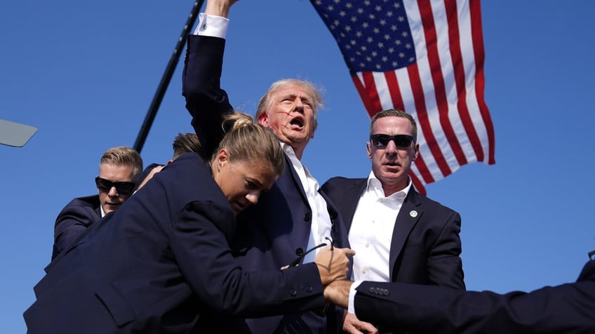 Donald Trump puts his fist in the air after an assassination attempt against him on July 13, 2024 on Butler, Pennsylvania. One of his supporters was killed in the shooting.