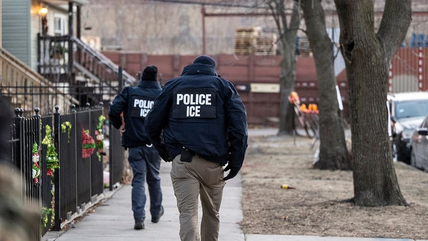 ICE agents walk down a street during a multi-agency targeted enforcement operation in Chicago on Sunday, Jan. 26, 2025.