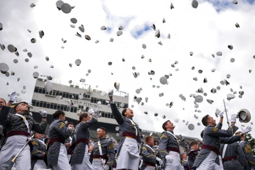 Graduates threw their hats into the air and marched accompanied by a military band