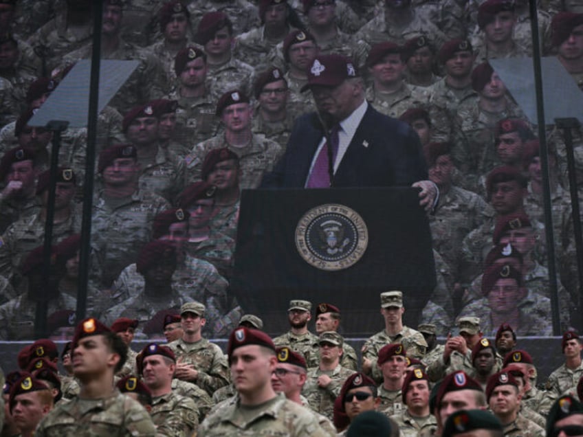 US President Donald Trump is seen on a screen as he speaks at Fort Bragg, a US Army milita