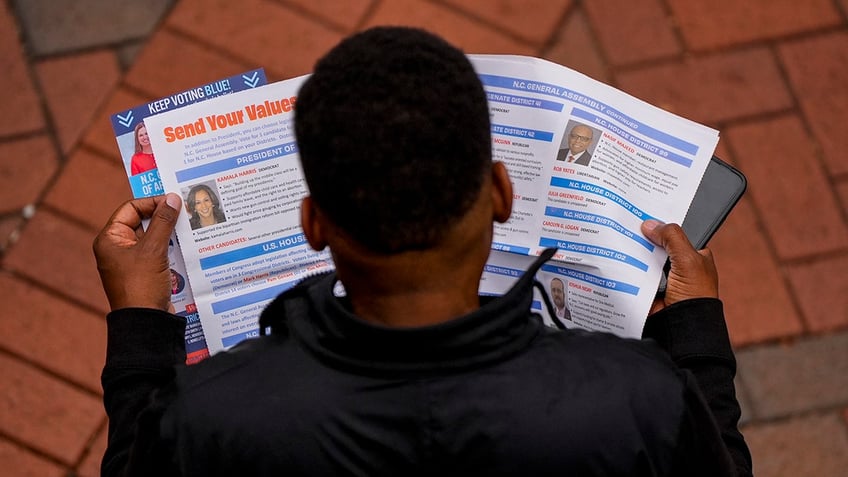 A man reads election materials before voting during the last day of early voting