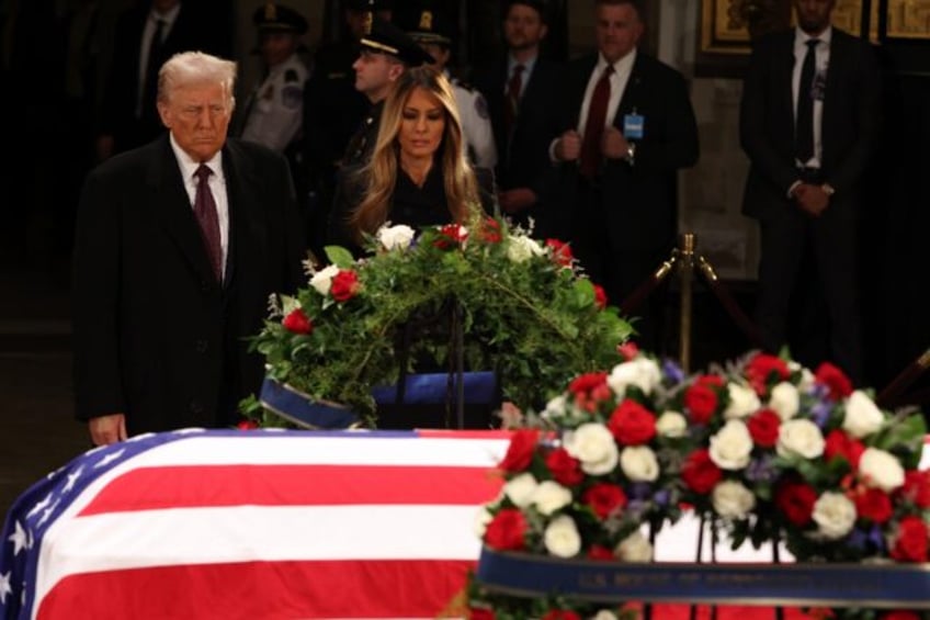 US President-elect Donald Trump and former US First Lady Melania Trump pay their respects