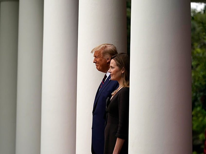 President Donald Trump walks with Judge Amy Coney Barrett to a news conference to announce Barrett as his nominee to the Supreme Court, in the Rose Garden at the White House, Saturday, Sept. 26, 2020, in Washington. (AP Photo/Alex Brandon)