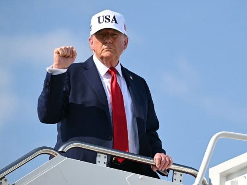 US President Donald Trump pumps his fist while boarding Air Force One at Joint Base Andrew
