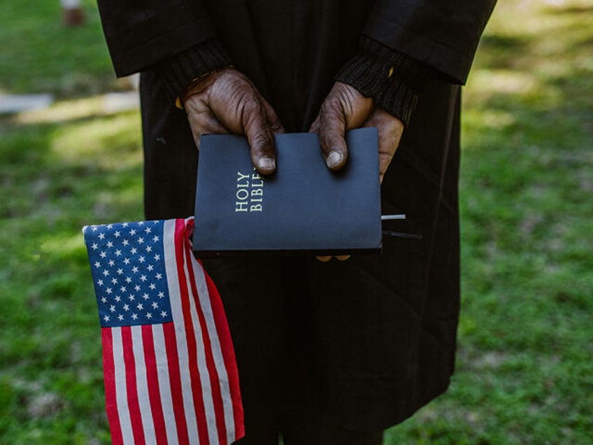Man holding Bible and American flag