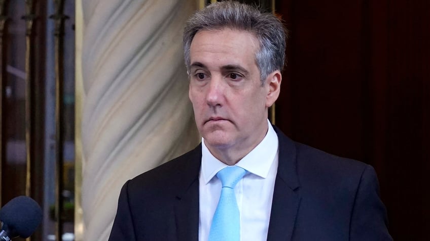 Michael Cohen in light blue tie and dark coat