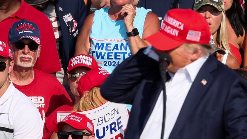 Donald Trump reacts as multiple shots rang out during a campaign rally