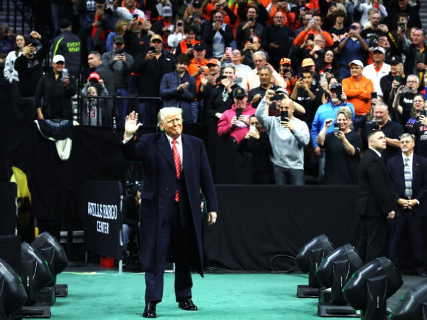 President Donald Trump waves as he arrives at the NCAA Division I Wrestling Championship o