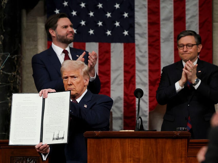 US President Donald Trump holds a signed executive order that renames a wildlife sanctuary