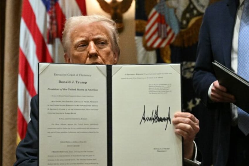 President Donald Trump displays a a pardon handed out to Devon Archer, a former business p