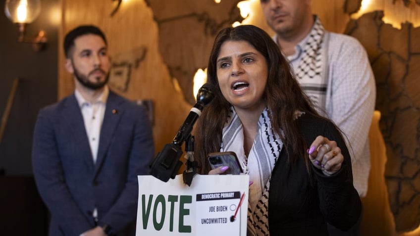 activist Lexis Zeidan, holding "vote uncommitted" sign