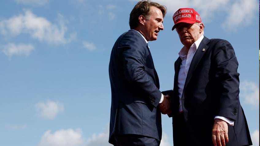 Former U.S. President Donald Trump shakes hands with Virginia Gov. Glenn Youngkin