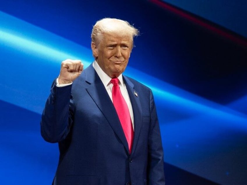 Donald Trump raises a fist at CPAC 2025.