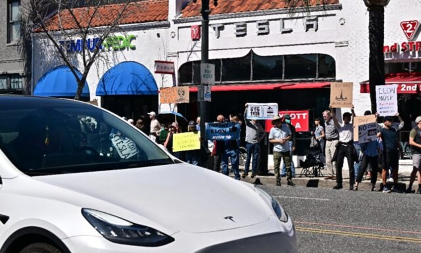 People participate in a protest against Elon Musk outside a Tesla dealership in Pasadena,