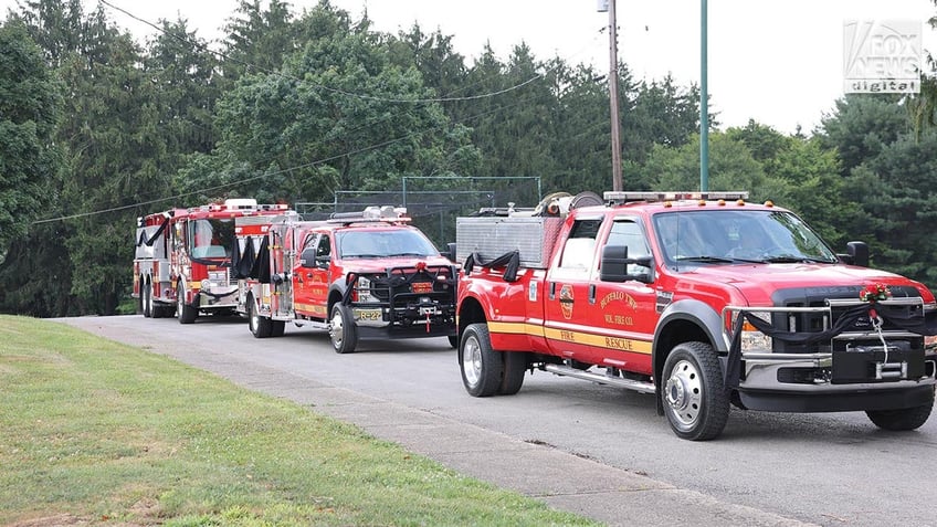 Fire trucks draped in black cloth