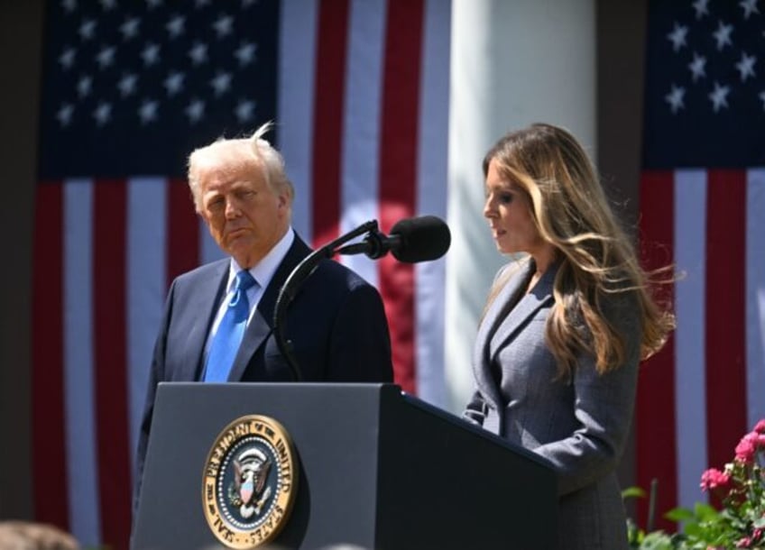 US President Donald Trump looks on as First Lady Melania Trump speaks at a signing ceremon