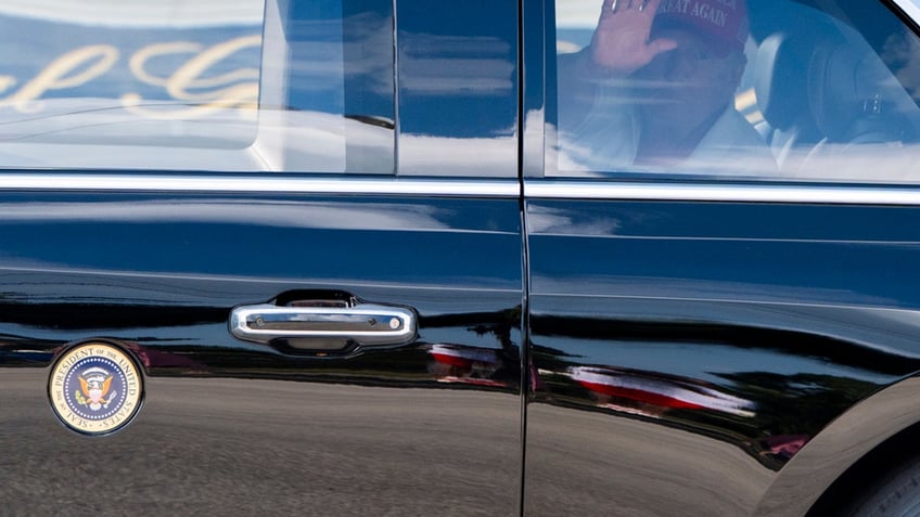 President Donald Trump waves as he departs in his motorcade from the Trump International Golf Club, Saturday, in West Palm Beach, Fla. 