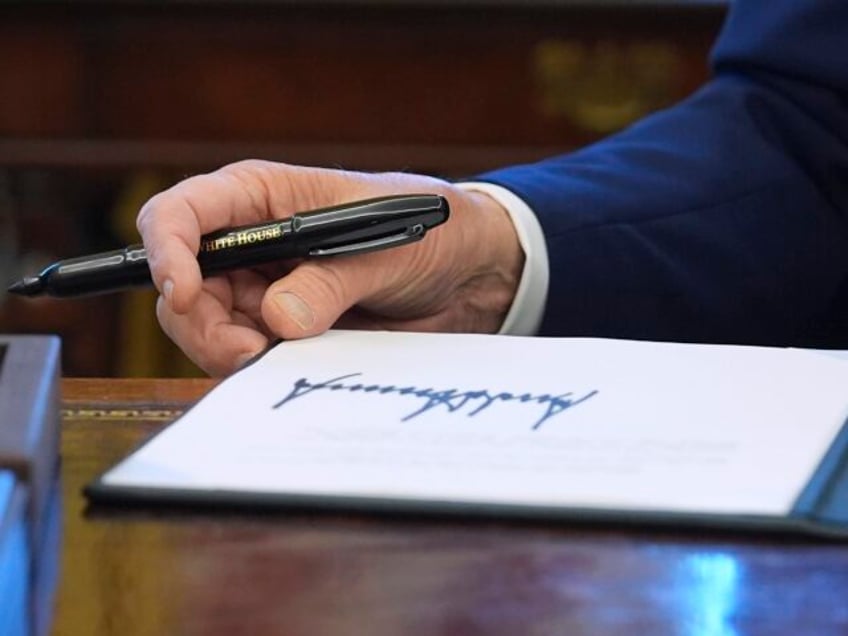 President Donald Trump signs executive orders in the Oval Office of the White House, Tuesd